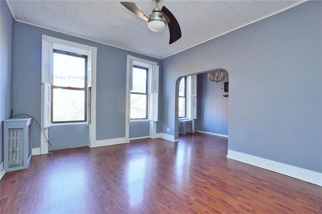 378 8th Street Brooklyn, NY 11215 - Photo 23 of 37 an empty room with wooden floor chandelier and windows