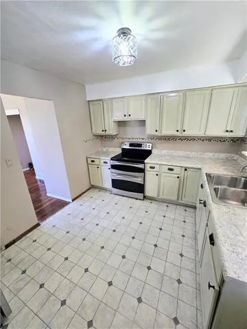 a kitchen with stainless steel appliances a stove a sink and a refrigerator