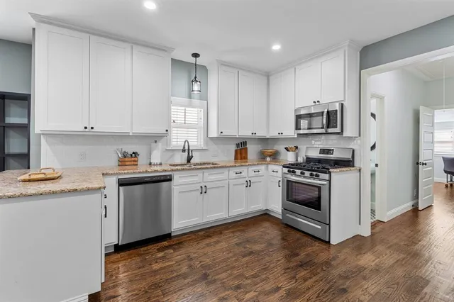 a kitchen with granite countertop white cabinets and white appliances