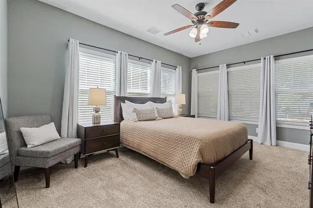 a bedroom with a bed a couch and a chandelier