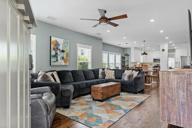 a living room with furniture kitchen view and a window