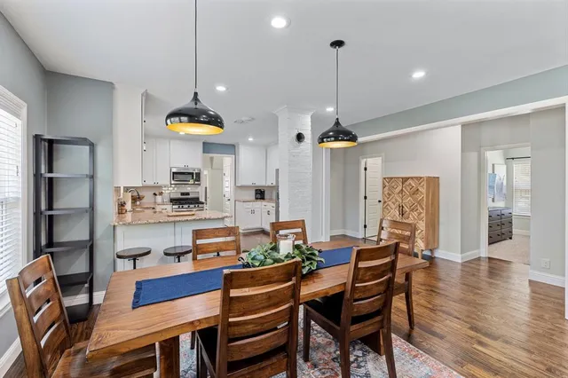 a dining room filled chandelier and wooden floor
