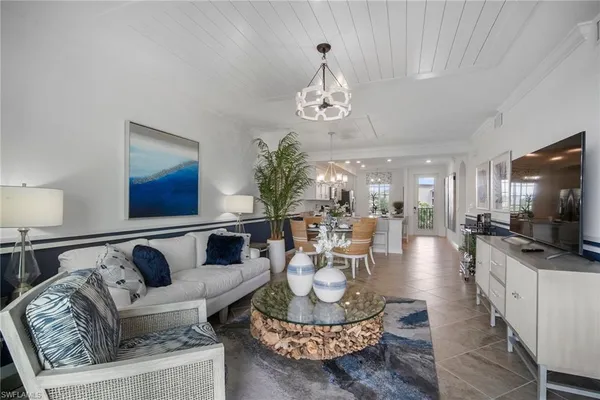 a living room with furniture a chandelier and a flat screen tv