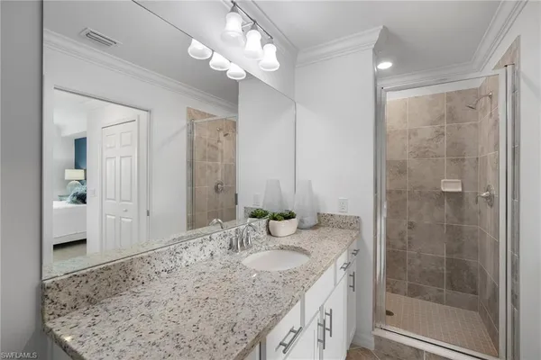 a bathroom with a granite countertop sink a mirror and a shower