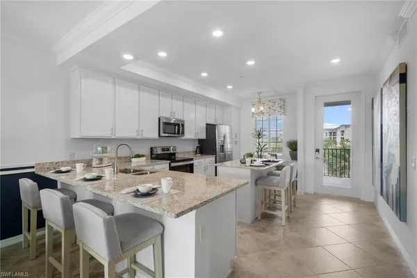 a kitchen with stainless steel appliances granite countertop a stove top oven a sink dishwasher a dining table and chairs with wooden floor