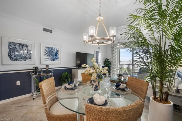 a view of a dining room with furniture a chandelier and wooden floor