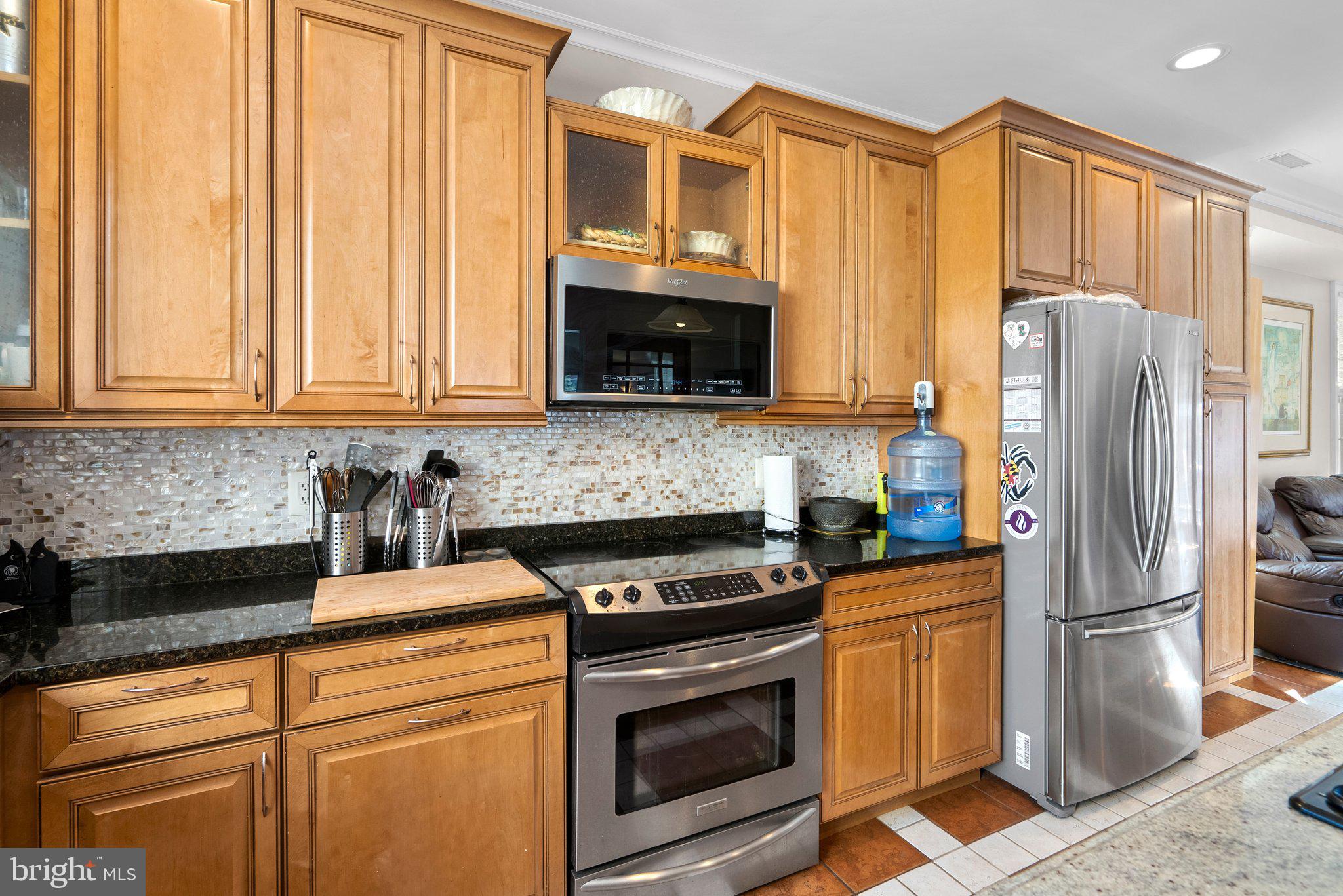 13131 Holdridge Road Silver Spring, MD 20906 - Photo 11 of 41 a kitchen with stainless steel appliances granite countertop a refrigerator stove microwave and sink