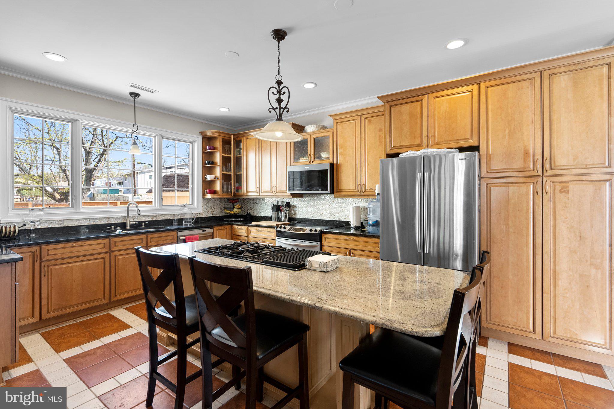 13131 Holdridge Road Silver Spring, MD 20906 - Photo 8 of 41 a kitchen with stainless steel appliances granite countertop a dining table chairs refrigerator and cabinets