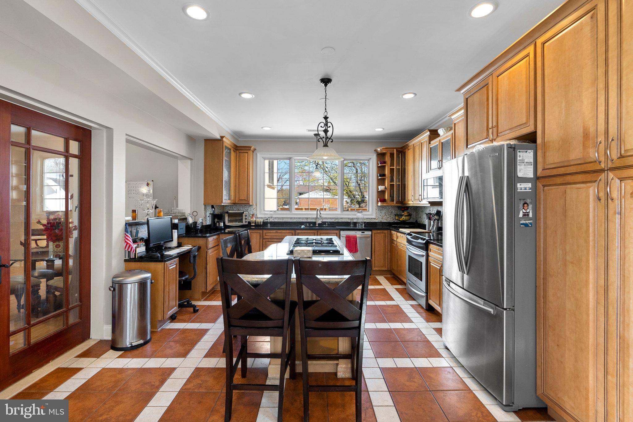 13131 Holdridge Road Silver Spring, MD 20906 - Photo 9 of 41 a kitchen with stainless steel appliances granite countertop a refrigerator a sink dishwasher a stove and a dining table with wooden floor