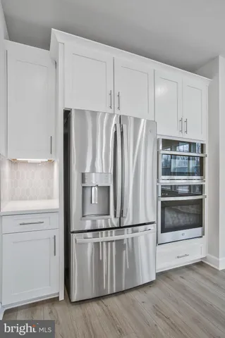 a view of kitchen with refrigerator and wooden floor