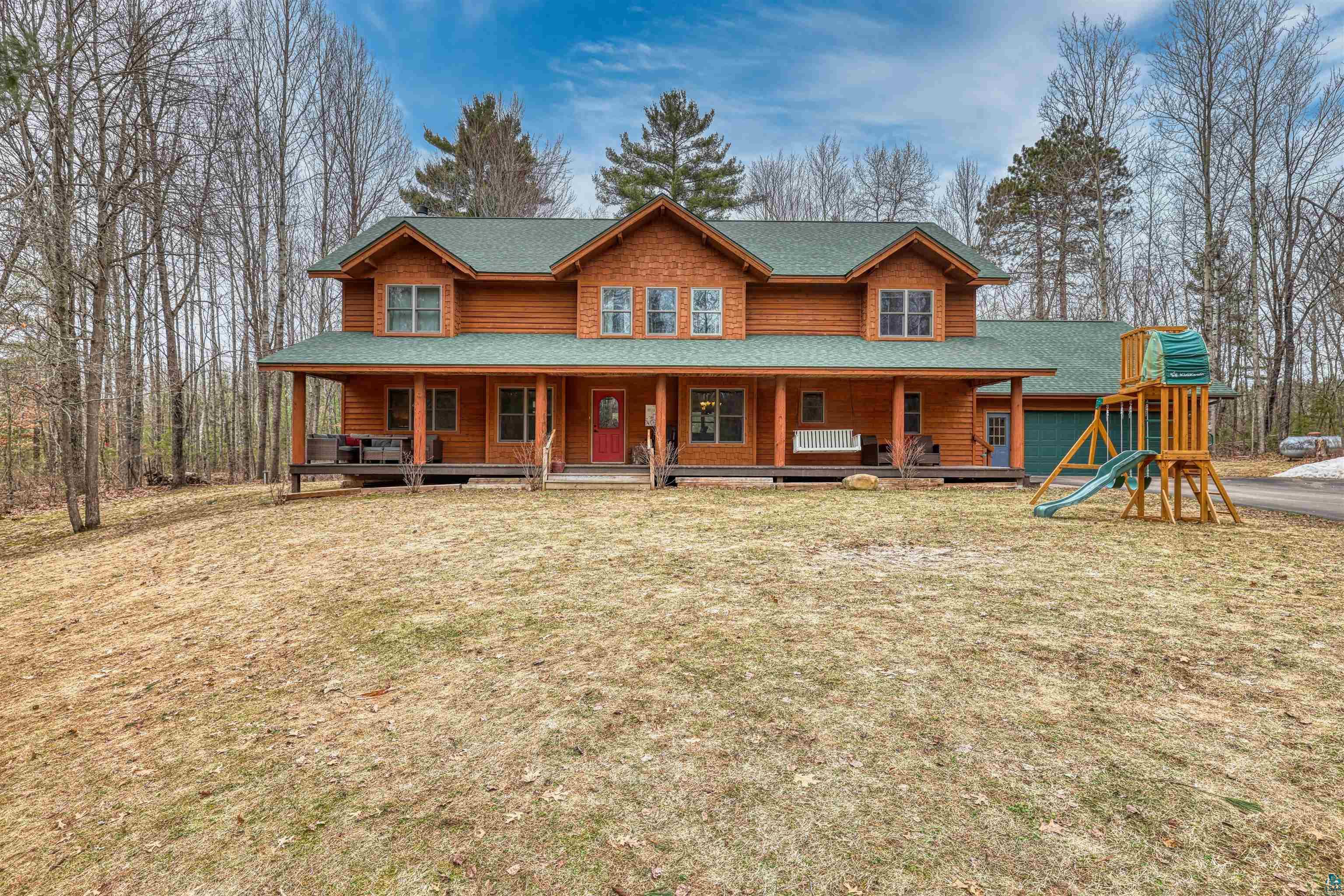 16539 Acorn Ridge Hayward, WI 54843 - Photo 2 of 58 View of front of home with a porch, a shingled roof, and a front lawn