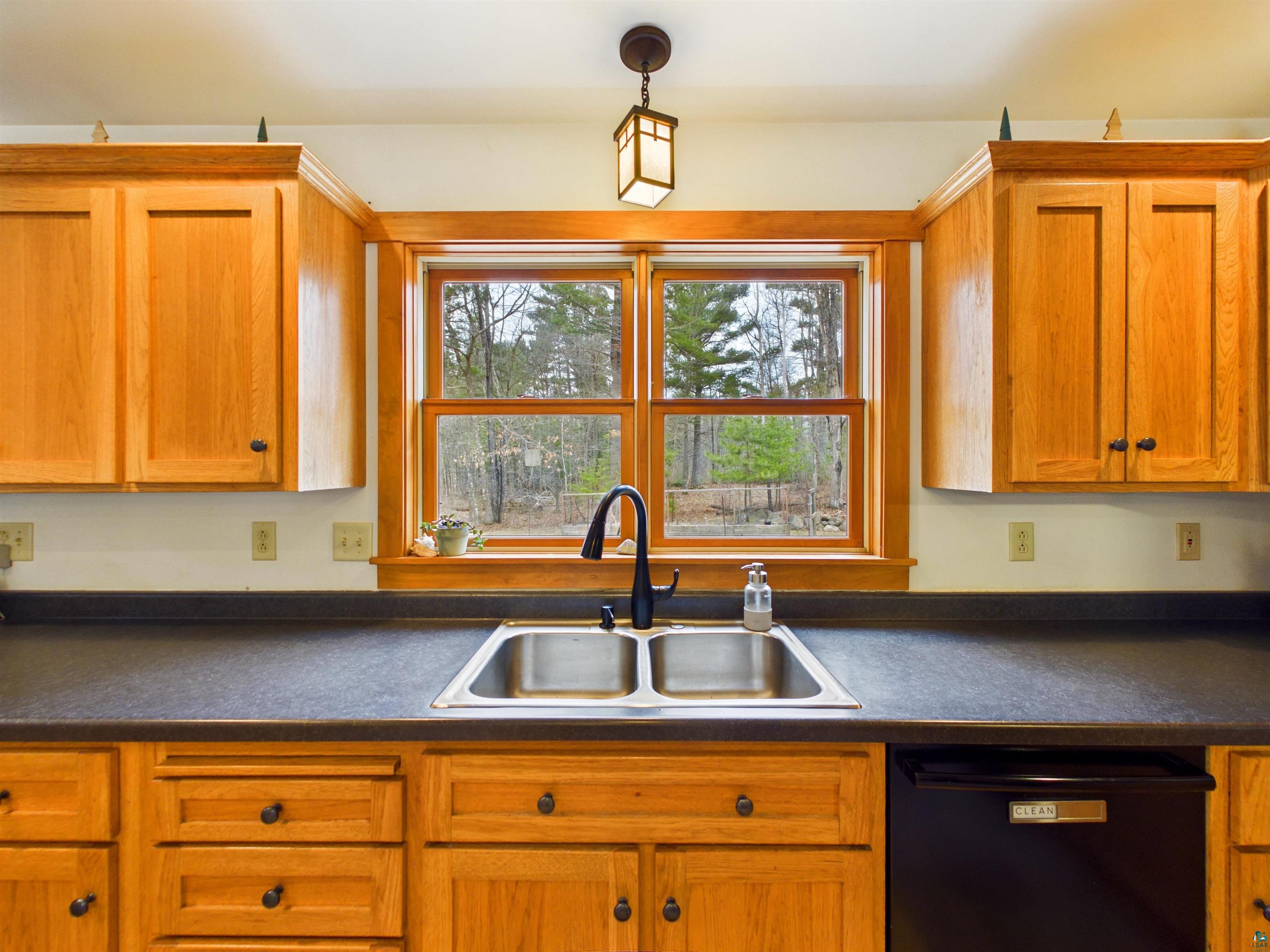 16539 Acorn Ridge Hayward, WI 54843 - Photo 22 of 58 Kitchen with black dishwasher, dark countertops, wood finish cabinets, and pendant lighting