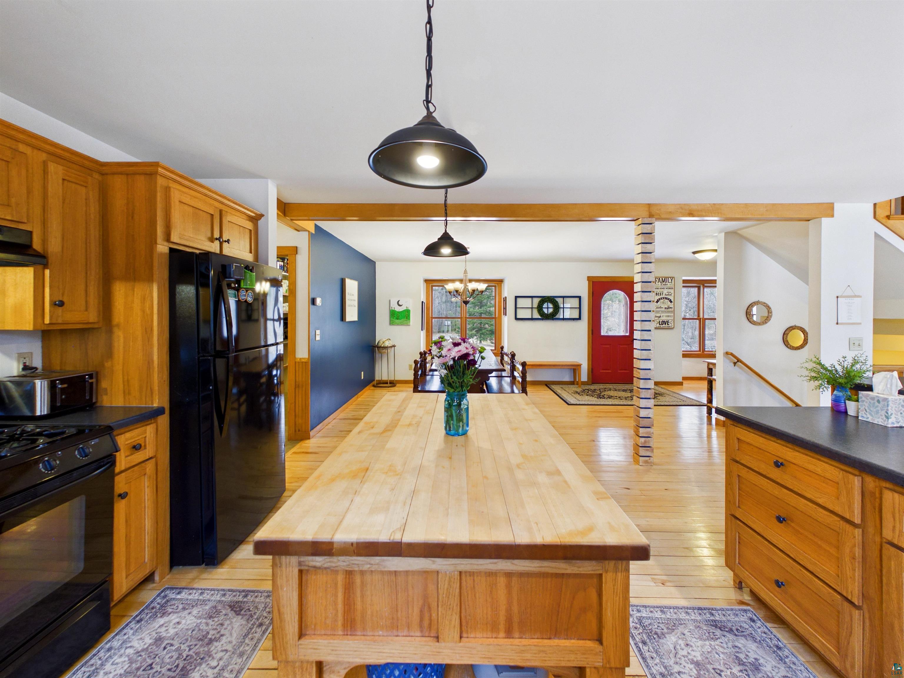 16539 Acorn Ridge Hayward, WI 54843 - Photo 23 of 58 Kitchen with wood finish cabinetry, black appliances, beamed ceiling, pendant lighting, and wooden counters