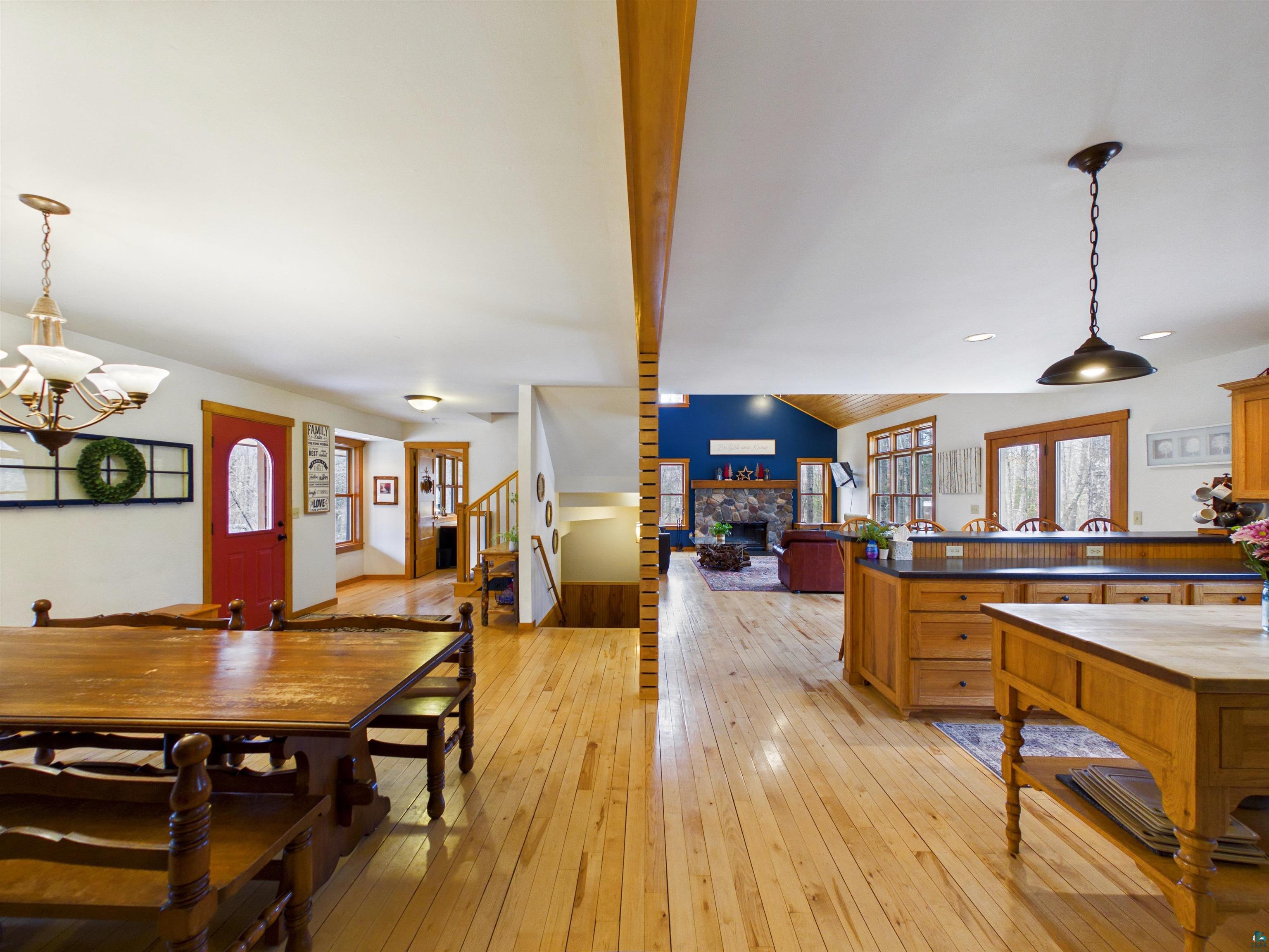 16539 Acorn Ridge Hayward, WI 54843 - Photo 29 of 58 Dining area with a fireplace, light wood-type flooring, hanging lights, and lofted ceiling with beams