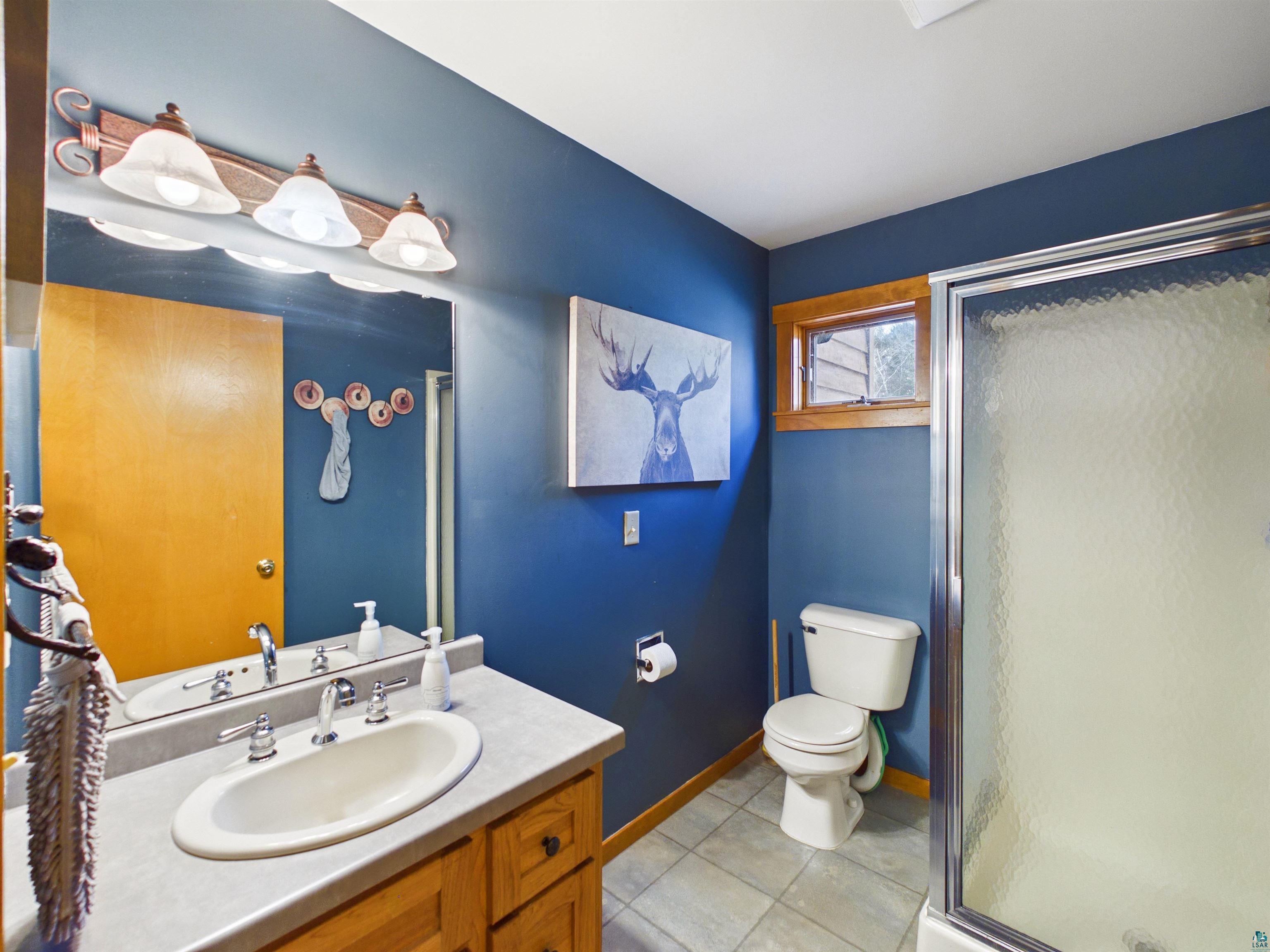 16539 Acorn Ridge Hayward, WI 54843 - Photo 30 of 58 Bathroom featuring vanity, a shower stall, and light tile patterned flooring