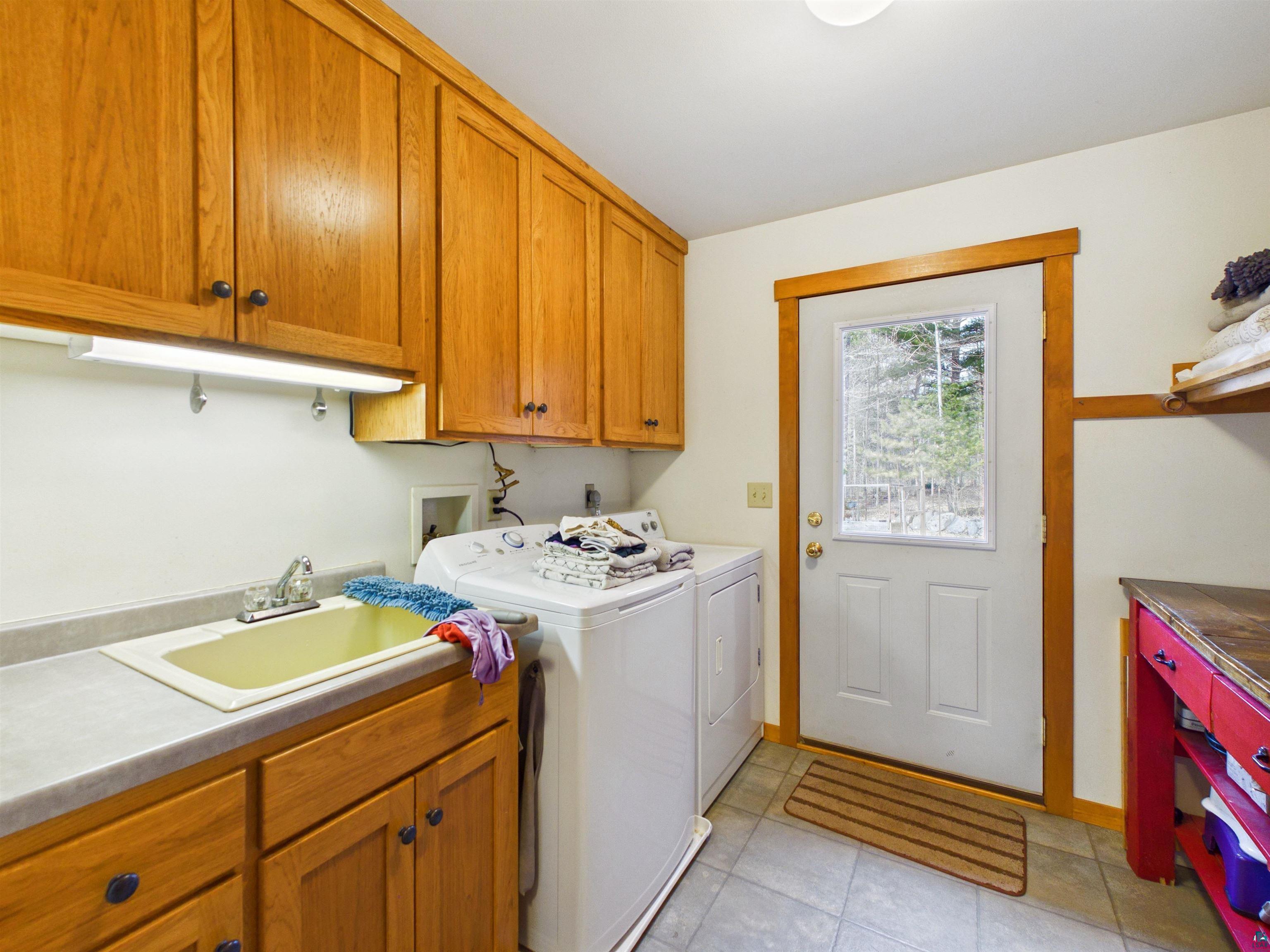 16539 Acorn Ridge Hayward, WI 54843 - Photo 33 of 58 Laundry area with independent washer and dryer, cabinet space, and light tile patterned floors