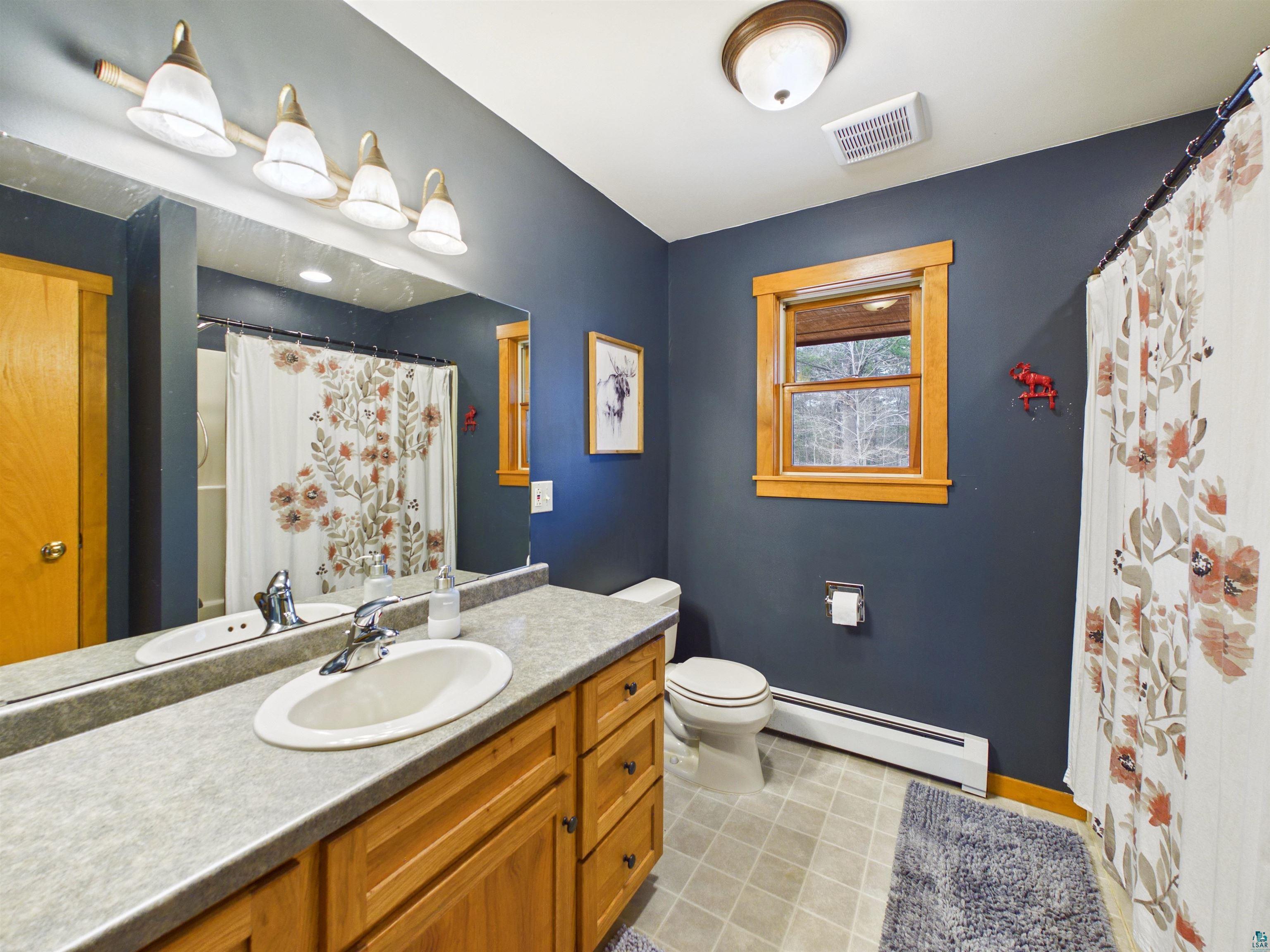 16539 Acorn Ridge Hayward, WI 54843 - Photo 37 of 58 Bathroom with a baseboard radiator, vanity, and a shower with curtain