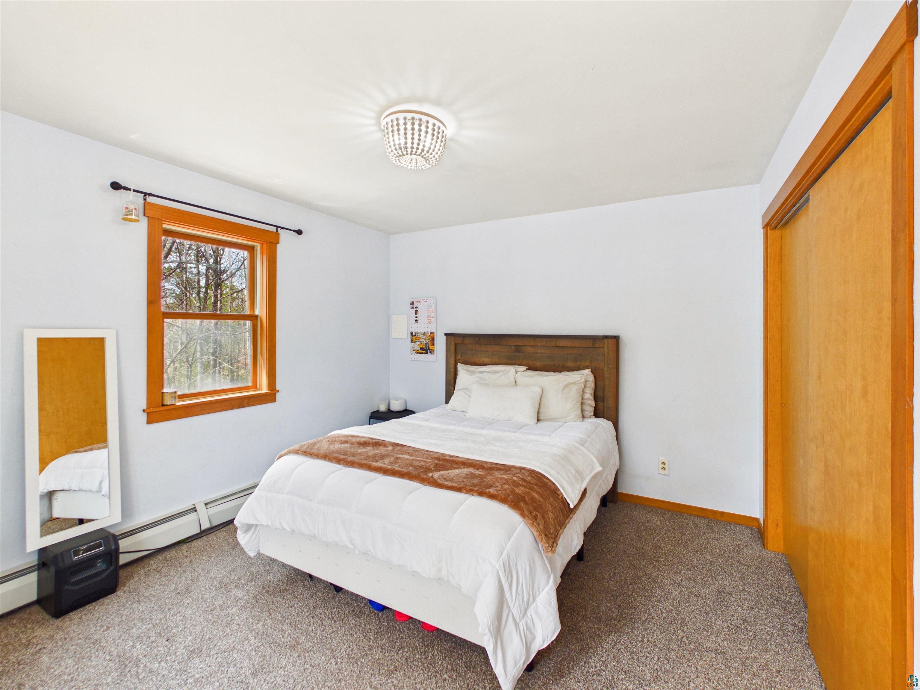 16539 Acorn Ridge Hayward, WI 54843 - Photo 42 of 58 Carpeted bedroom featuring baseboard heating and a closet