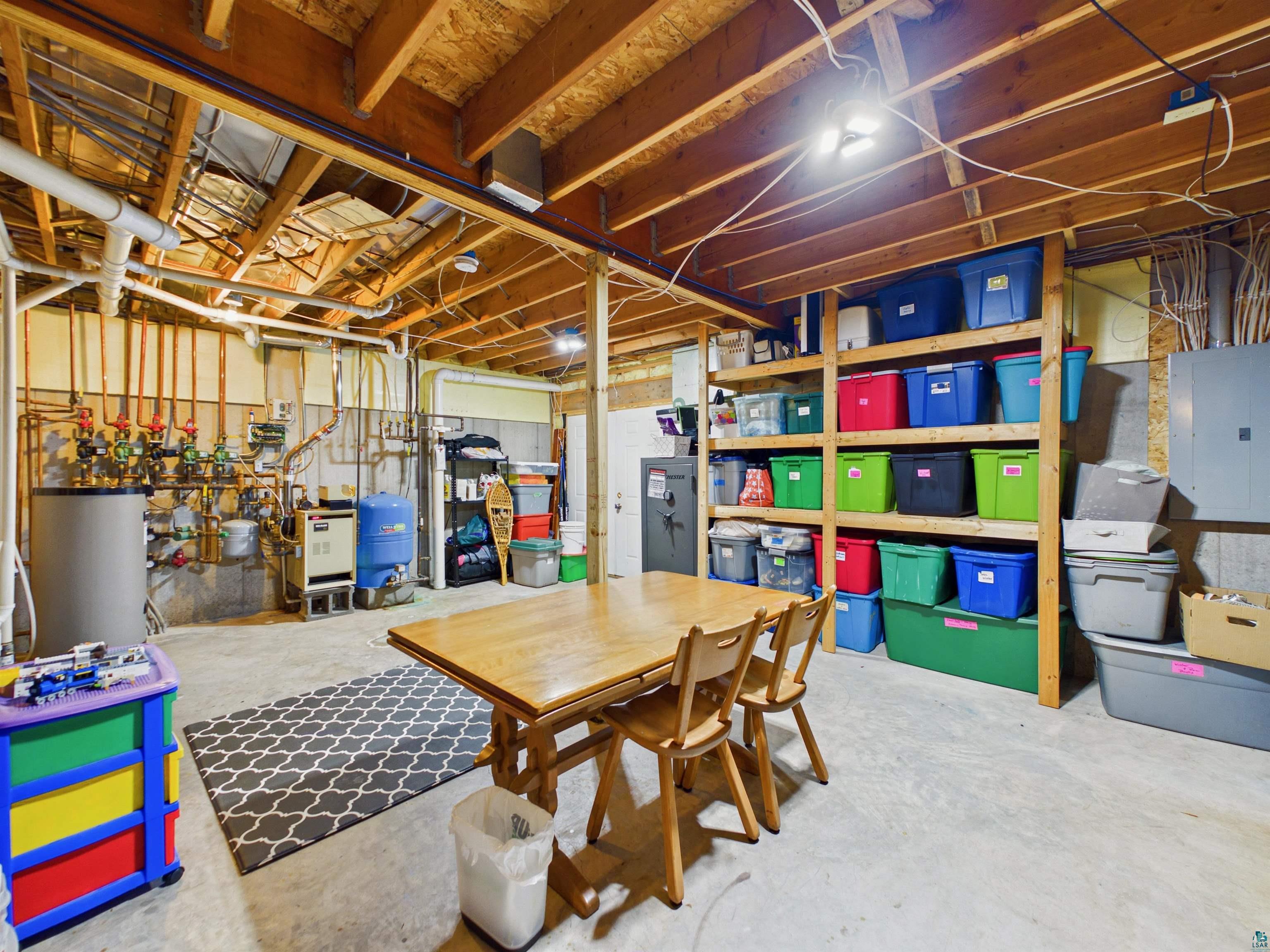 16539 Acorn Ridge Hayward, WI 54843 - Photo 49 of 58 Unfinished basement with electric panel, a water pressure tank, and gas water heater