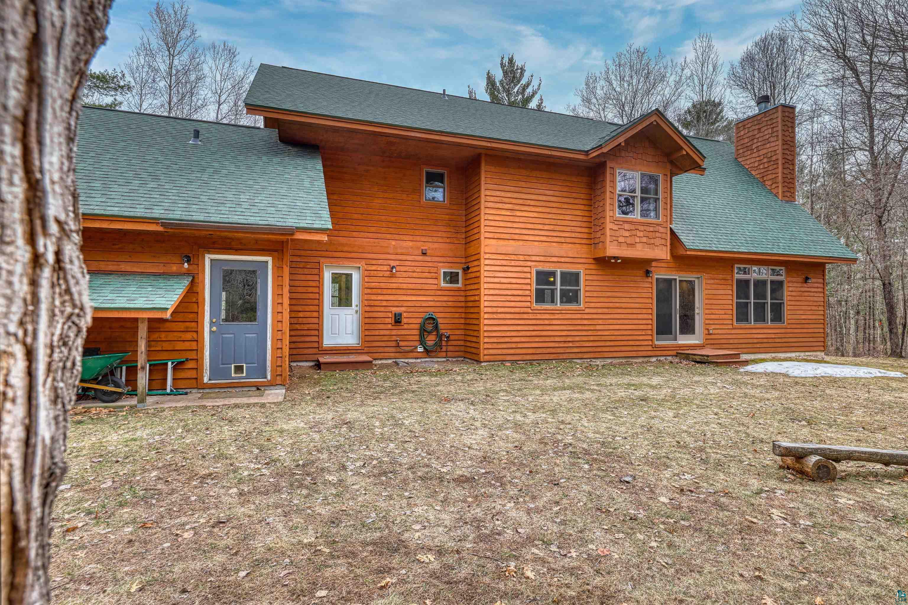 16539 Acorn Ridge Hayward, WI 54843 - Photo 52 of 58 Rear view of property featuring roof with shingles and a chimney