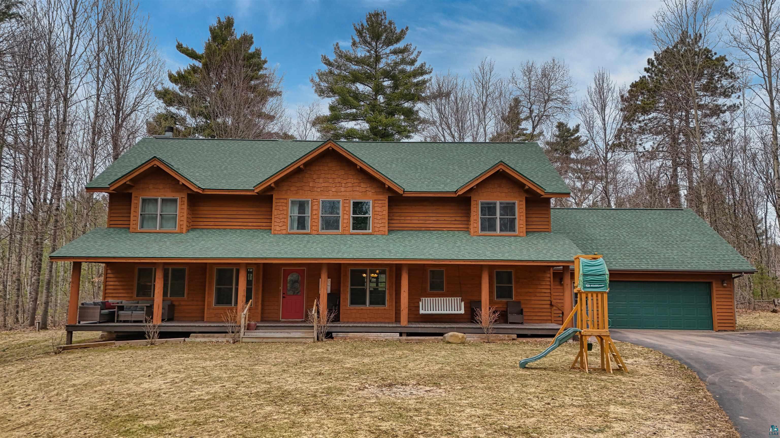 16539 Acorn Ridge Hayward, WI 54843 - Photo 56 of 58 View of front facade with roof with shingles, a porch, asphalt driveway, and a garage