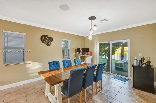 a view of a roof deck with table and chairs under an umbrella with a small yard