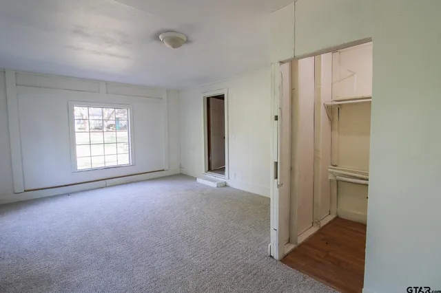 an empty room with windows and closet
