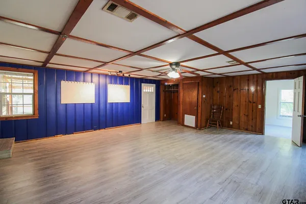 an empty room with wooden floor and windows
