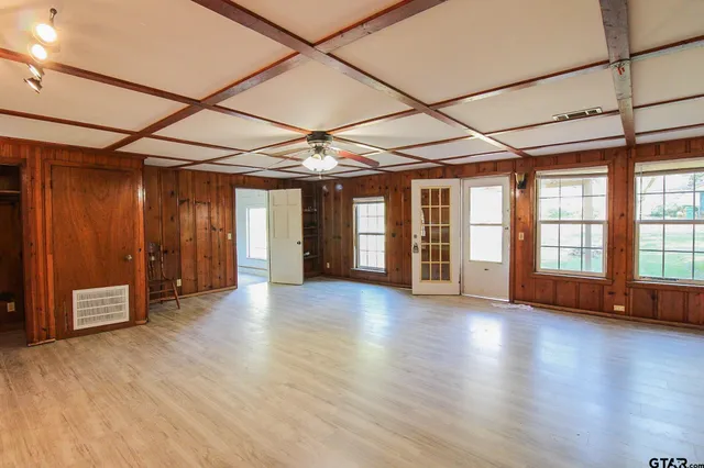 en empty room with wooden floor and windows