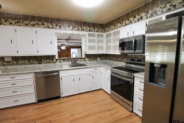 a kitchen with a sink stainless steel appliances and cabinets