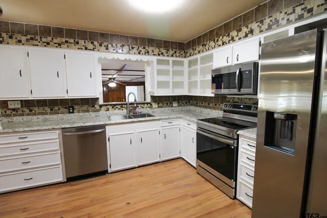 a kitchen with a sink stainless steel appliances and cabinets