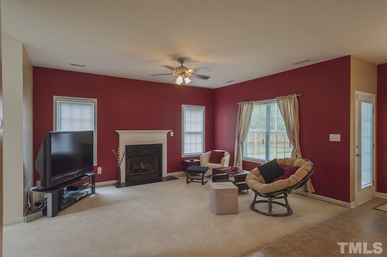 3239 Polite Lane Raleigh, NC 27610 - Photo 6 of 17 a living room with furniture a fireplace and a flat screen tv