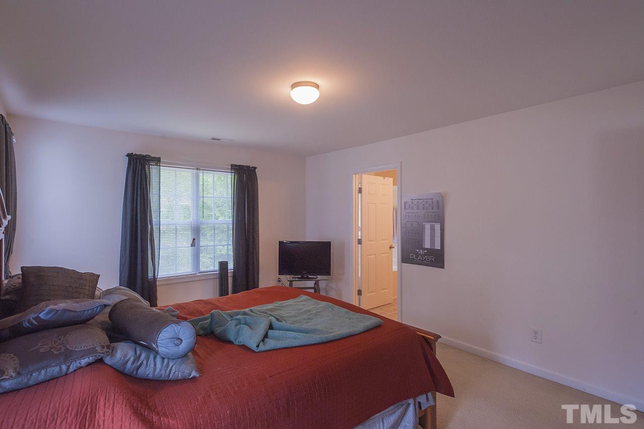 3239 Polite Lane Raleigh, NC 27610 - Photo 10 of 17 a bedroom with a bed and wooden floor
