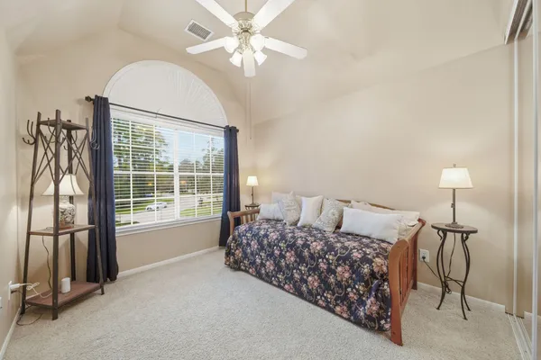 a large bedroom with bed and a chandelier