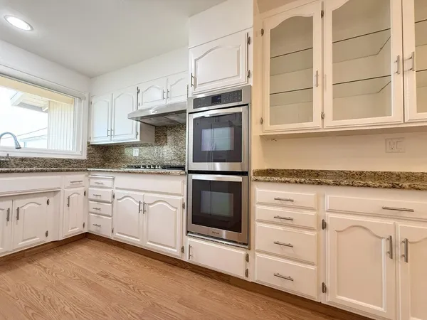 a kitchen with granite countertop white cabinets and a counter top space