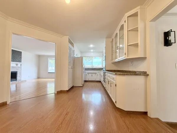a kitchen with granite countertop white cabinets and white appliances