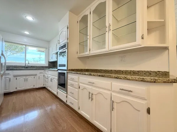 a kitchen with stainless steel appliances granite countertop a stove and white cabinets