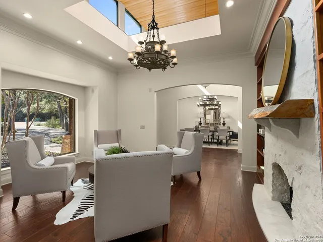 a living room with fireplace a chandelier furniture and a fireplace