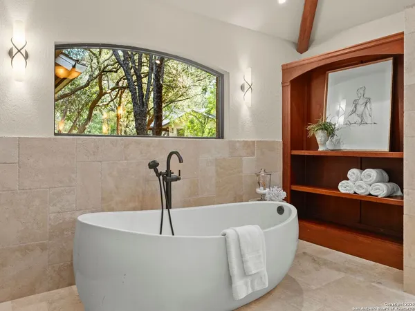 a bathroom with a granite countertop sink a mirror and a bathtub