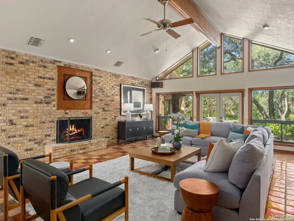 a living room with furniture a fireplace and a floor to ceiling window