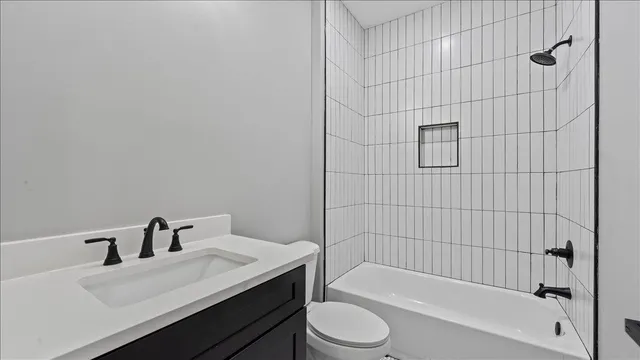 a bathroom with a bathtub shower sink vanity and toilet