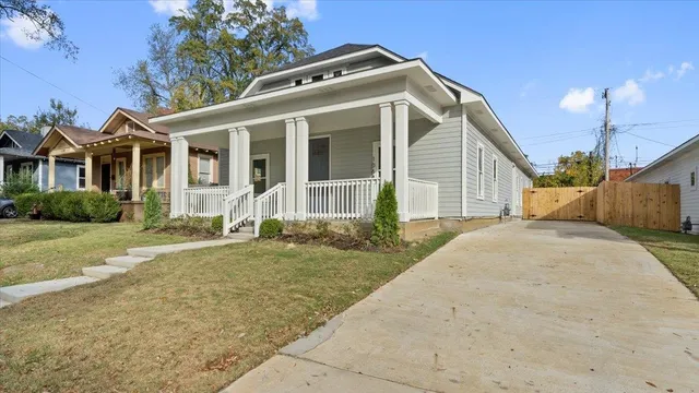 a front view of a house with a garden and plants
