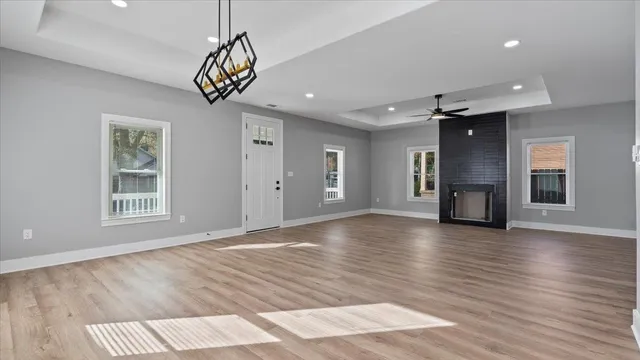 a view of an empty room with window and wooden floor