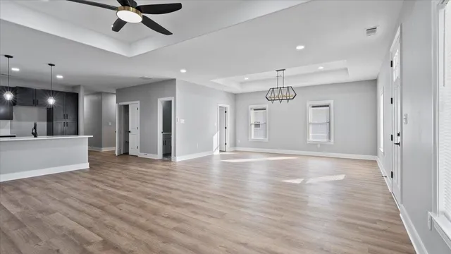 a view of a livingroom with a ceiling fan wooden floor and window