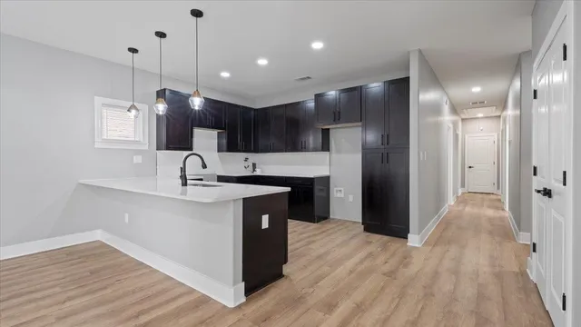 a kitchen with kitchen island a sink stainless steel appliances and wooden floor