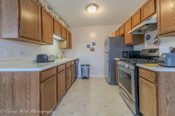 a kitchen with stainless steel appliances granite countertop a stove a sink and a refrigerator