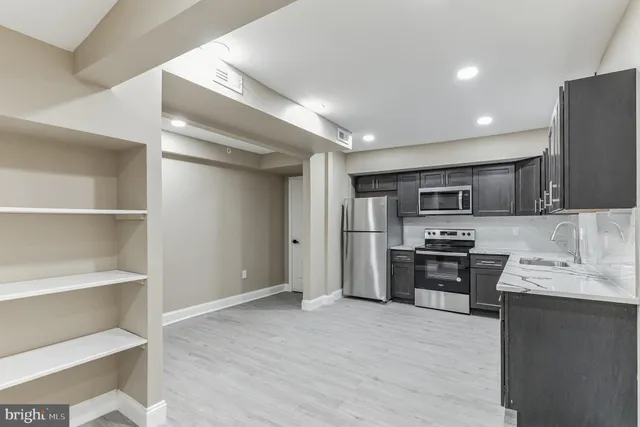 a kitchen with stainless steel appliances a stove refrigerator and a sink