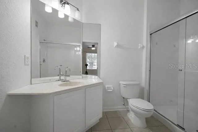a bathroom with a toilet a sink a mirror and vanity