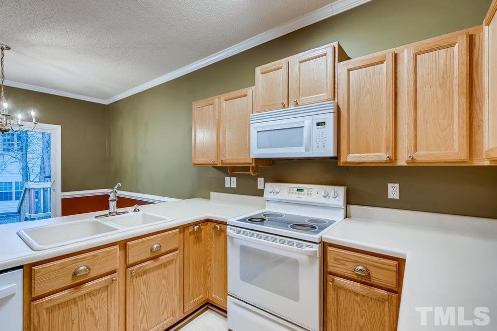 4008 Beaufain Street Raleigh, NC 27604 - Photo 12 of 30 a kitchen with stainless steel appliances granite countertop a sink stove and cabinets