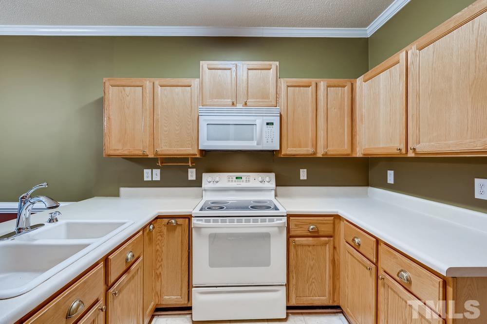 4008 Beaufain Street Raleigh, NC 27604 - Photo 13 of 30 a kitchen with stainless steel appliances granite countertop a sink and cabinets